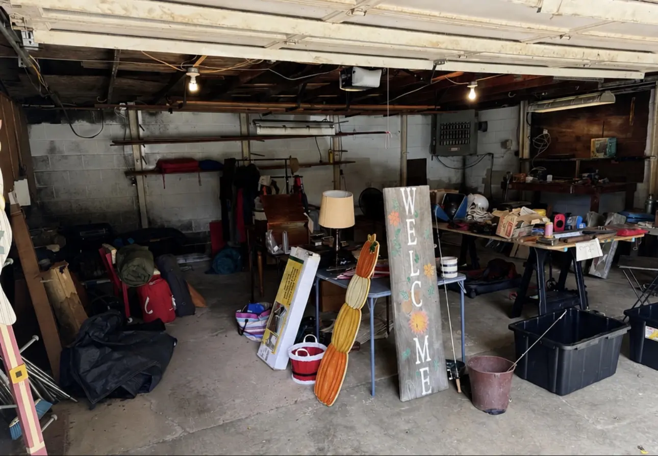 Before: a two-car garage packed with furniture, a lamp, a welcome sign, totes and tools.