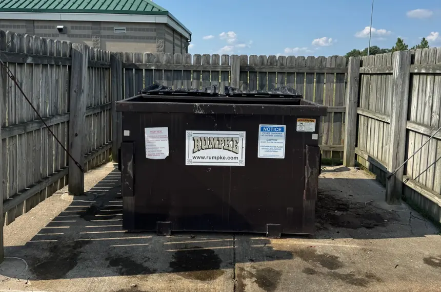 After: the same dumpster enclosure with the bags and overflow cleared.