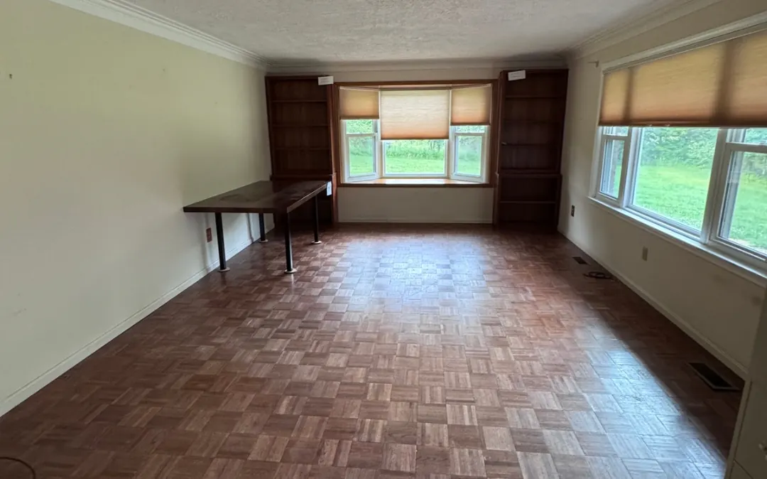 After: the same living room, empty. Piano, desk, boxes and filing cabinet all hauled out.