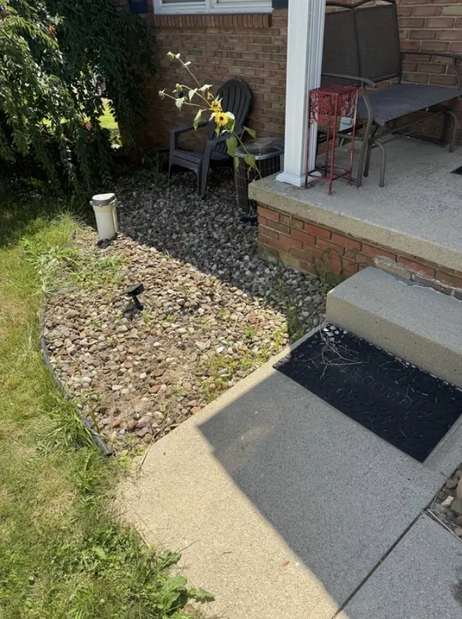 After: the same porch corner, cleared to the gravel bed.