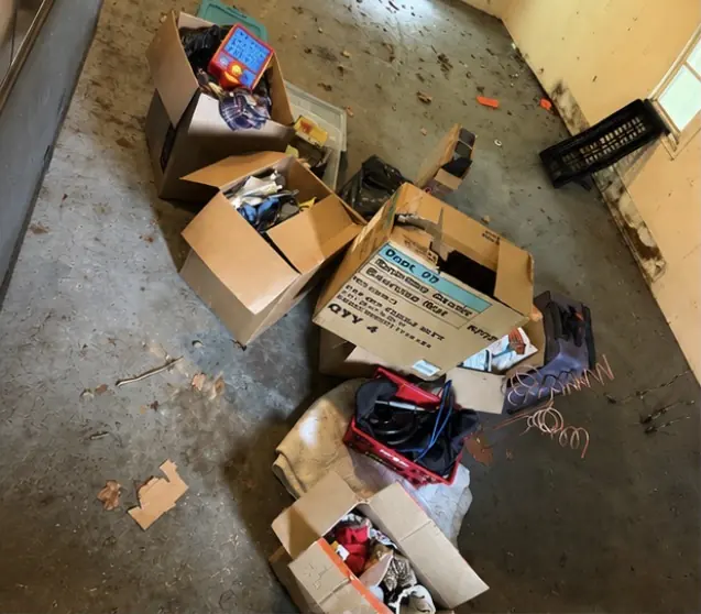 Before: open boxes and household clutter in the middle of an empty room.
