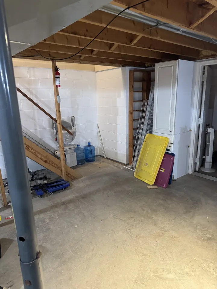 After: the same basement corner with a bare concrete floor.